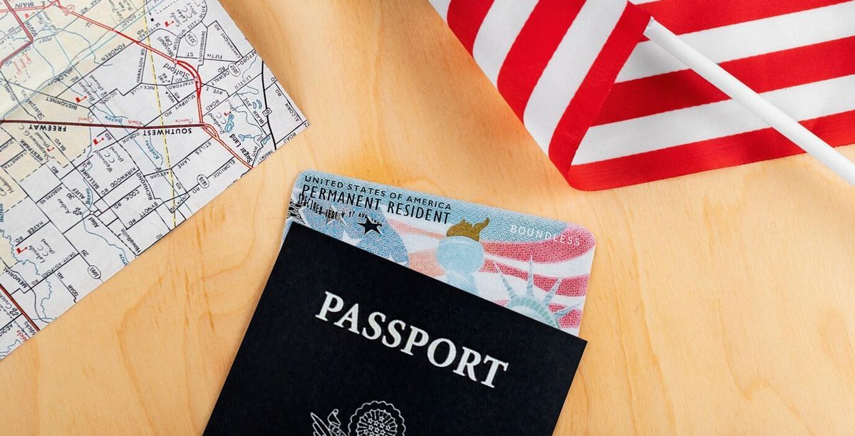 A passport and a united states flag on a wooden table