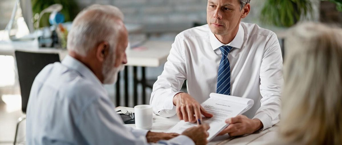 A group of men are sitting at a table talking to each other.