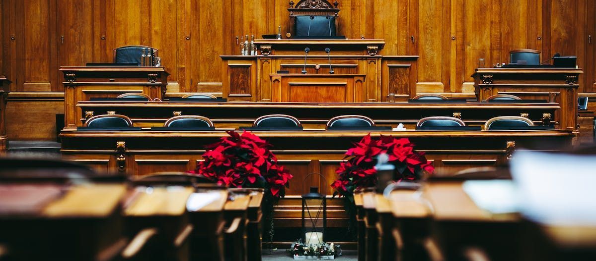 A wooden courtroom with red poinsettia flowers on the benches