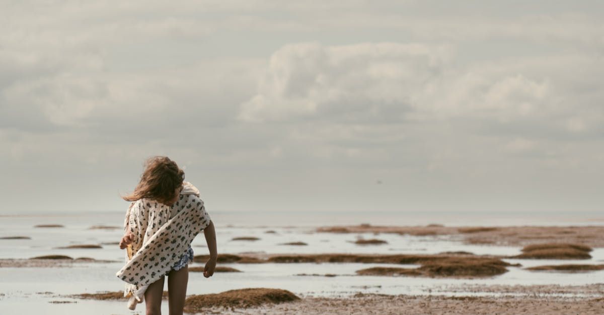 A little girl is walking along the beach.