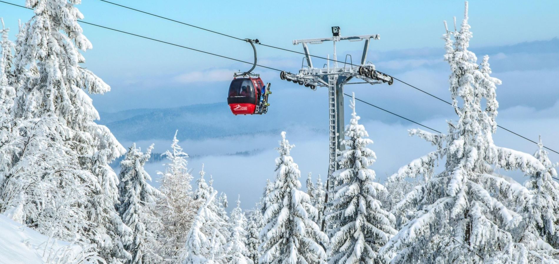 A ski lift is going up a snow covered mountain