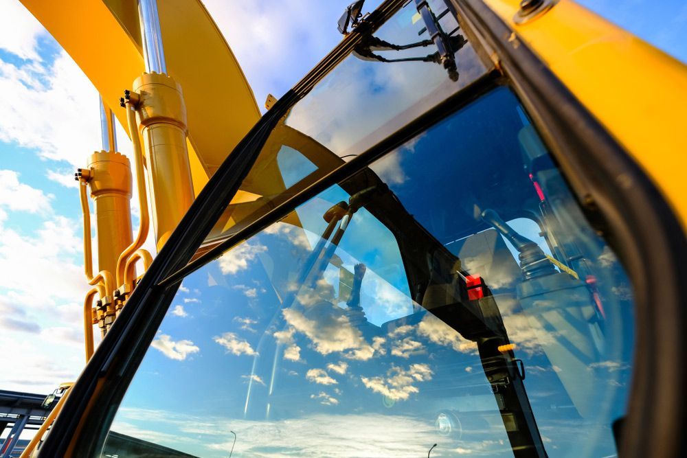 Blue Sky Reflecting Off a Yellow Excavator's Windscreen  — Windscreen Specialist in Dubbo, NSW