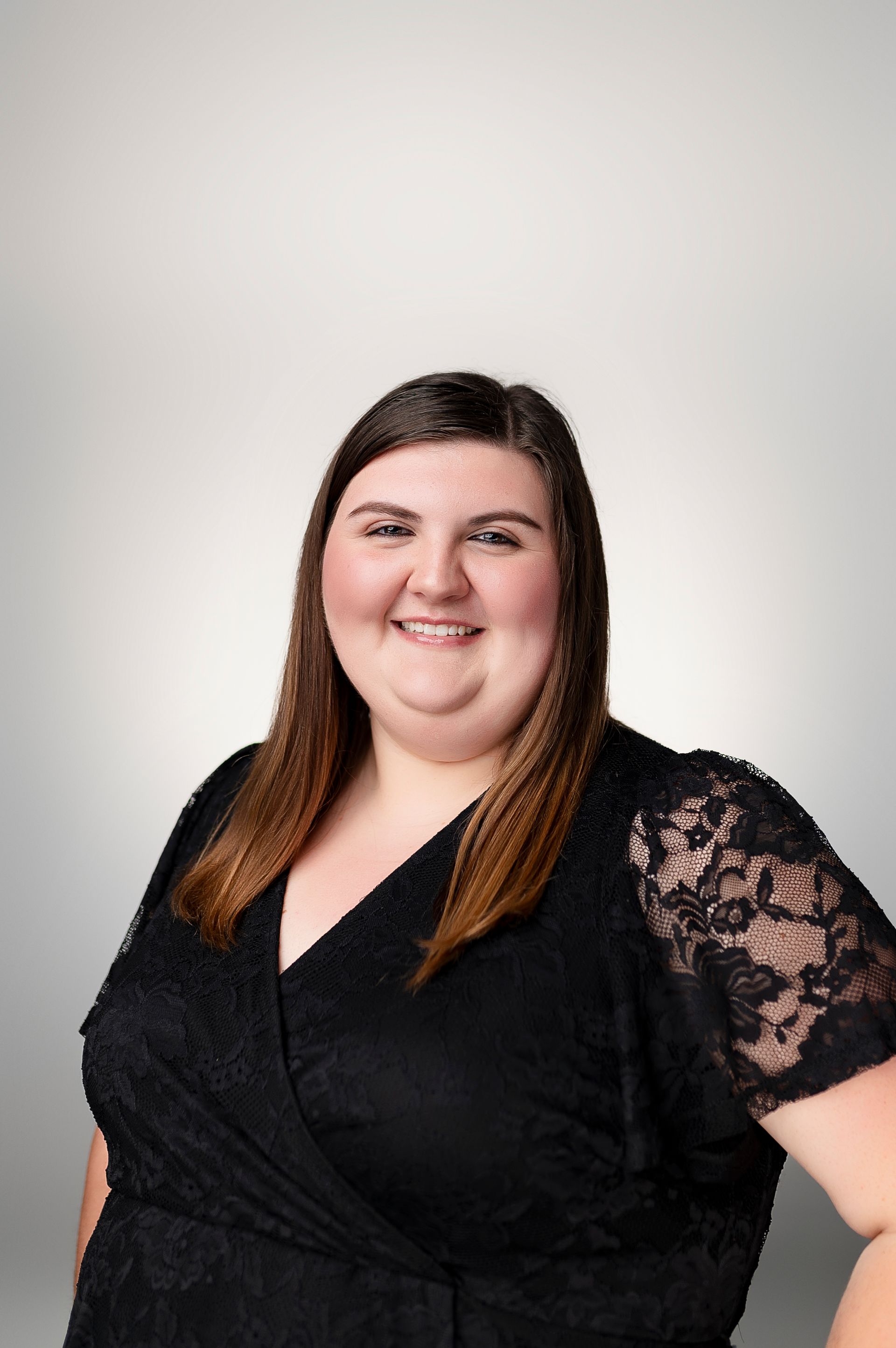 A woman in a black dress is smiling for the camera.