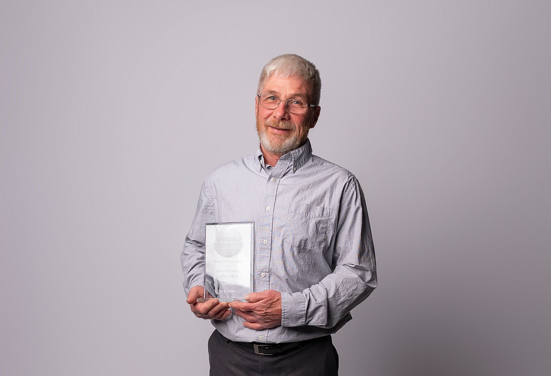 A man with a beard is holding a trophy in his hands.