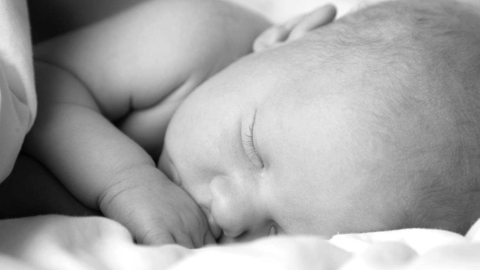 black and white image of a newborn sleeping