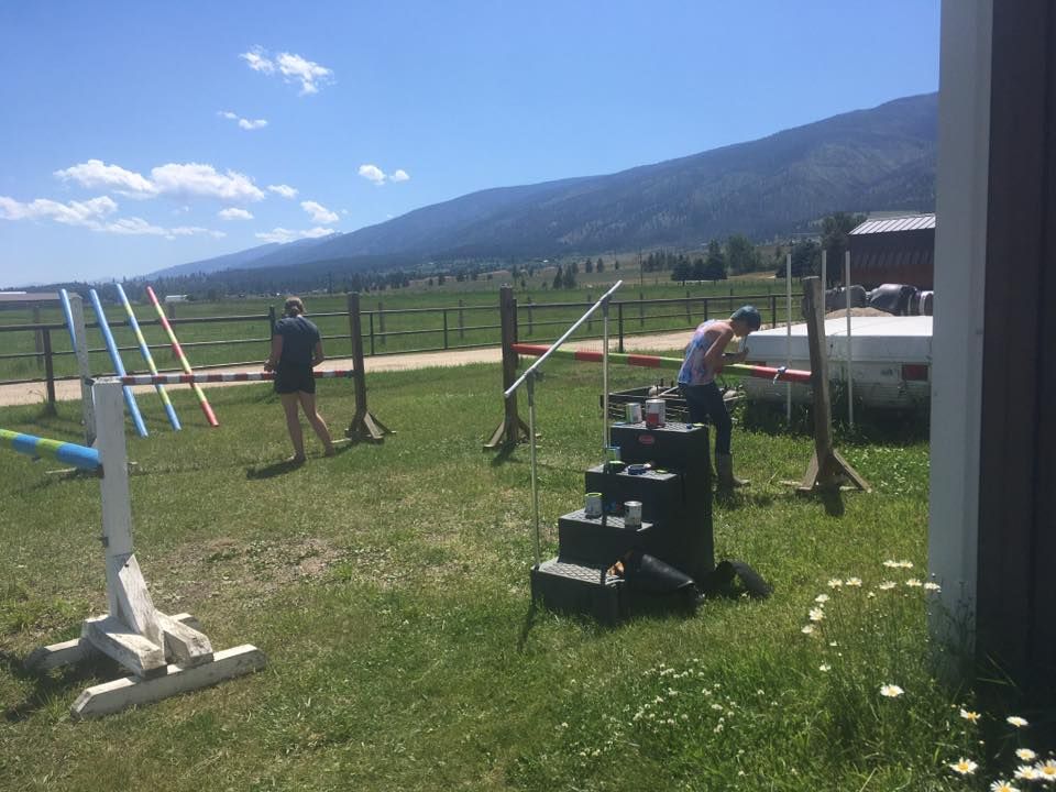 A group of people are working on a fence in a field.