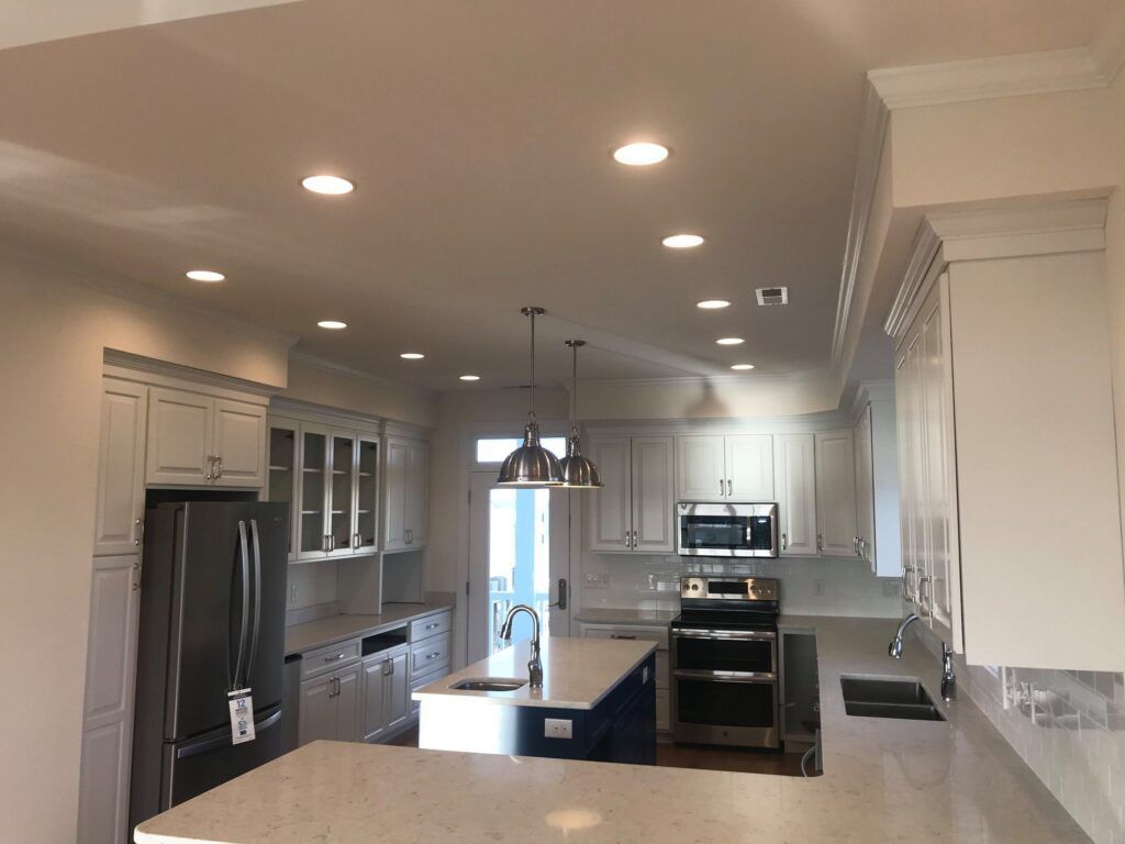A Kitchen with White Cabinets and Stainless Steel Appliances — Brunswick County, NC — Coastal Carolina Construction