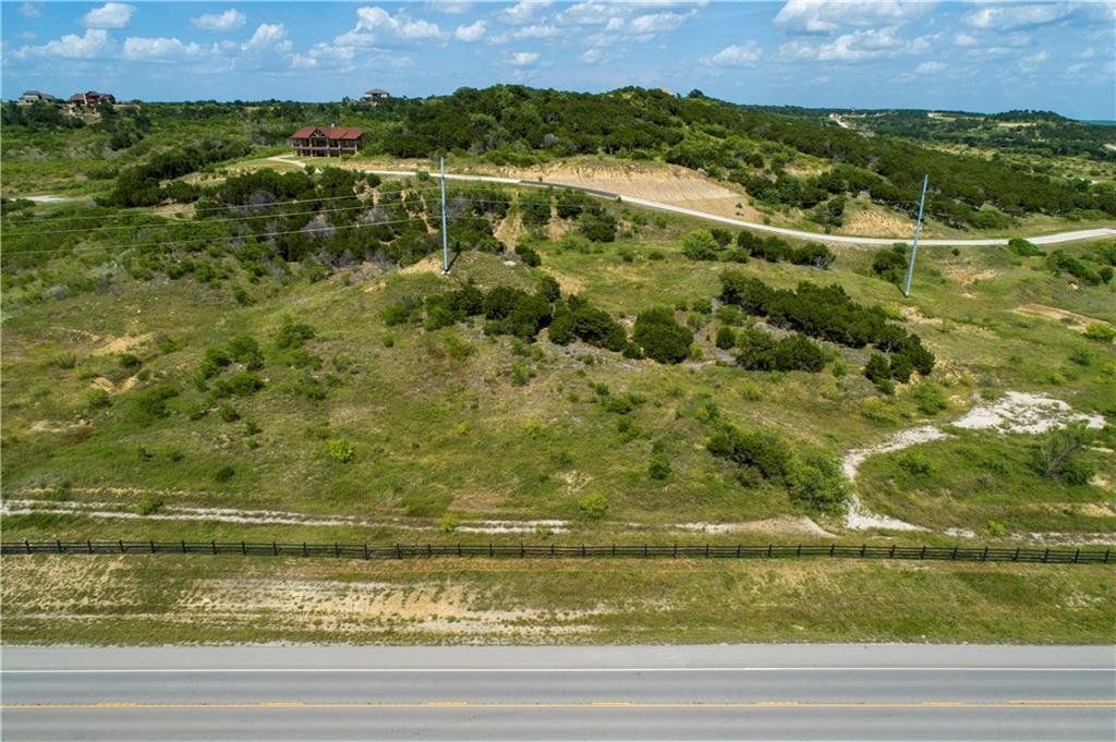 An aerial view of a grassy hillside next to a road.