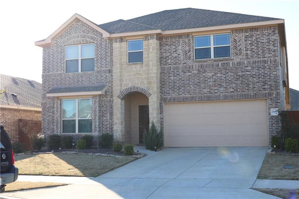 A large brick house with a car parked in front of it.