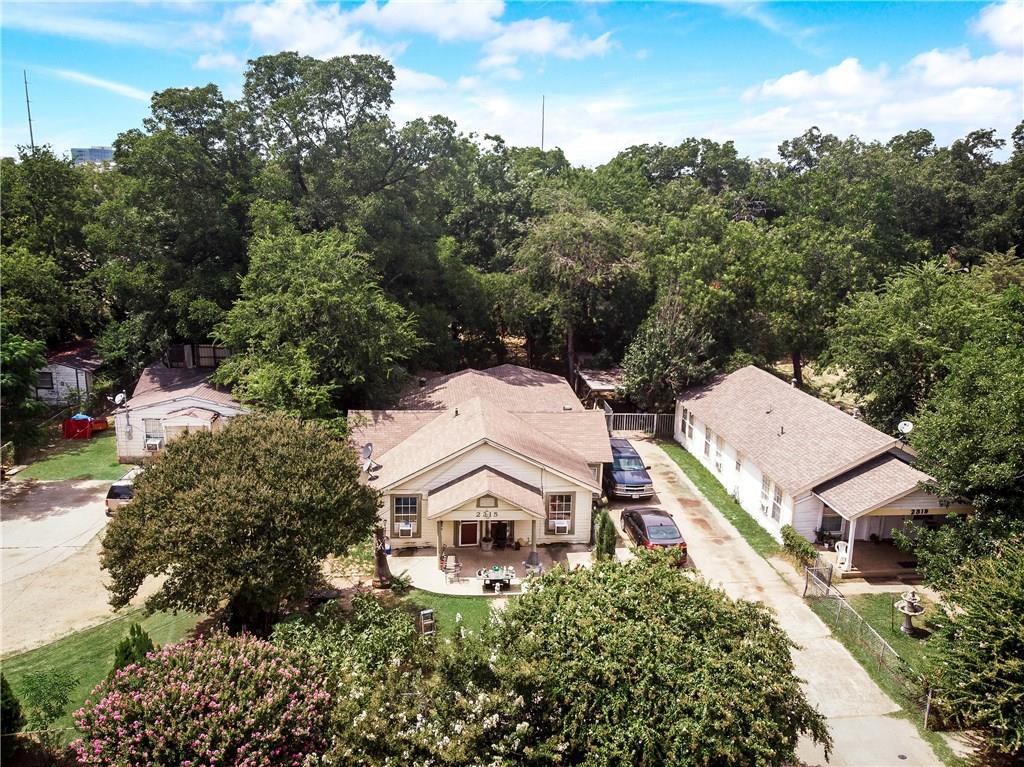 An aerial view of a row of houses surrounded by trees.