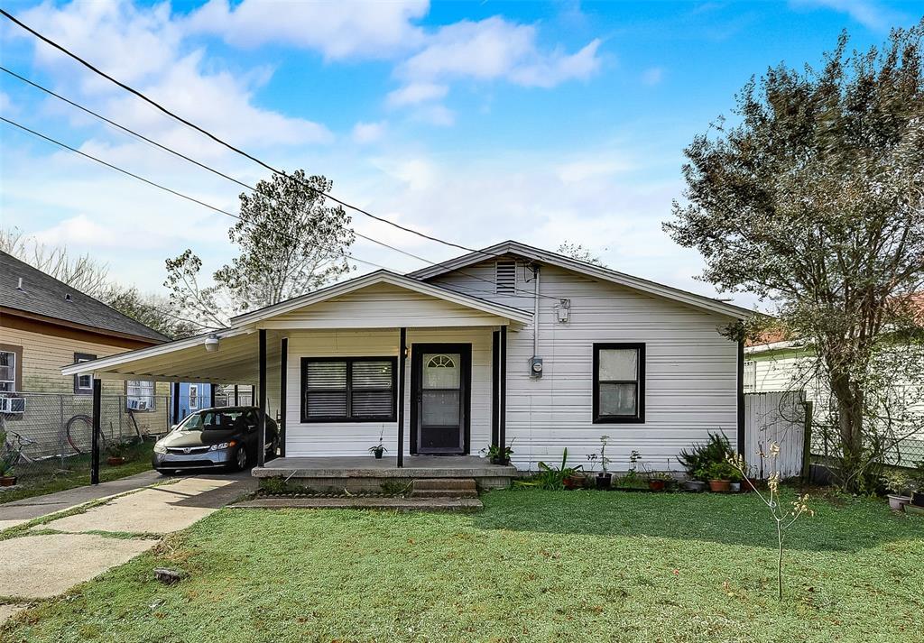 A white house with a car parked in front of it.