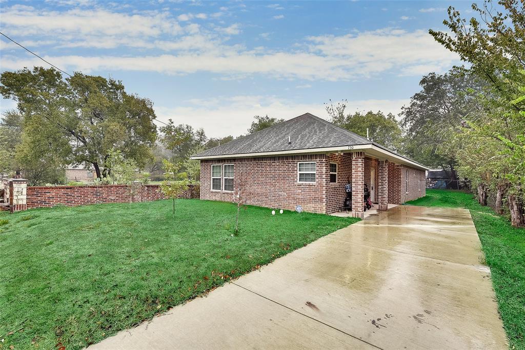A brick house with a driveway leading to it