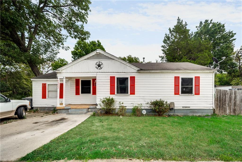 A white house with red shutters and a white truck parked in front of it.