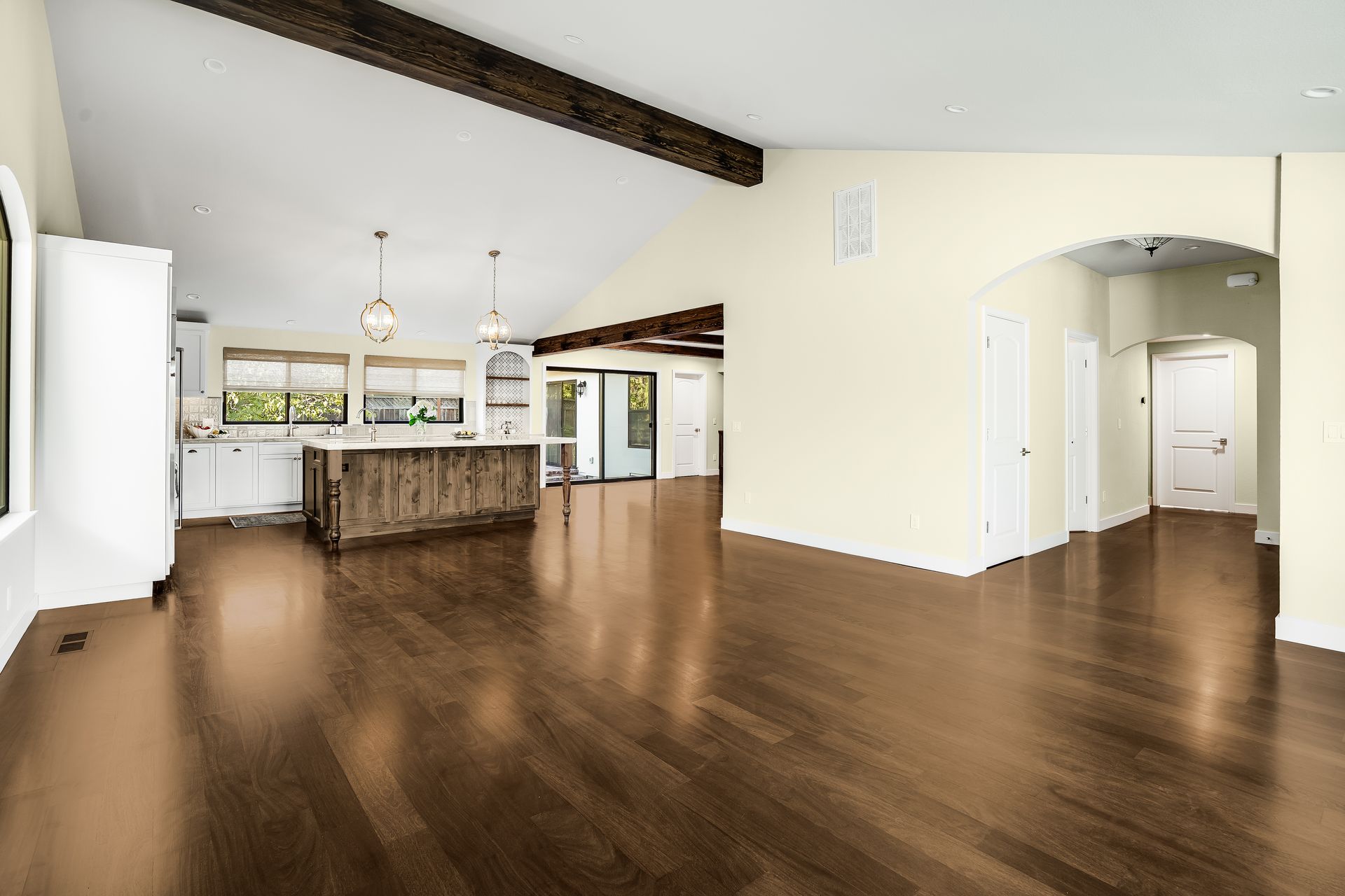 Spacious interior with hardwood floors, kitchen island, and vaulted ceiling.