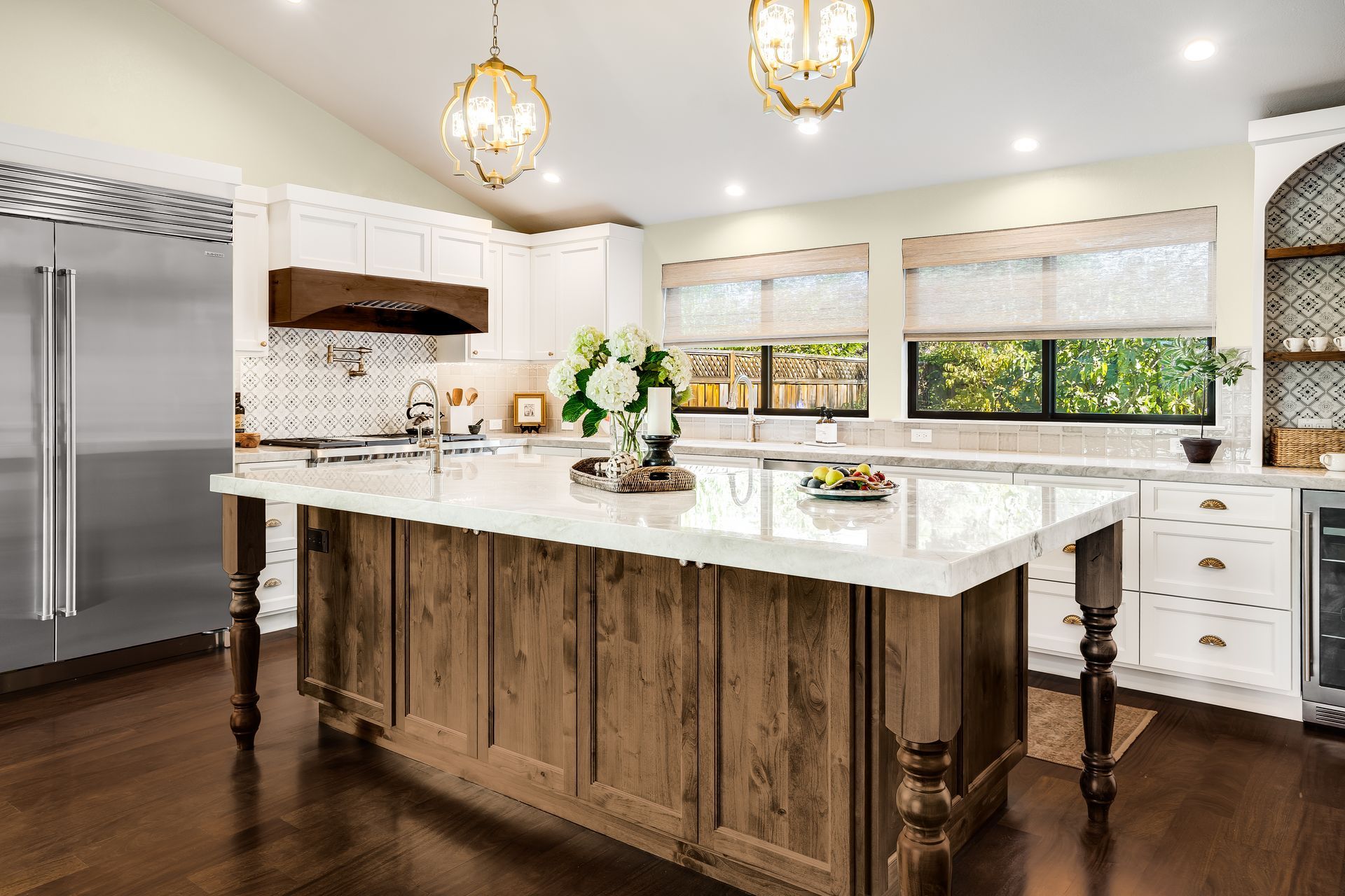Elegant kitchen with a large wooden island, white cabinets, and stainless steel appliances.