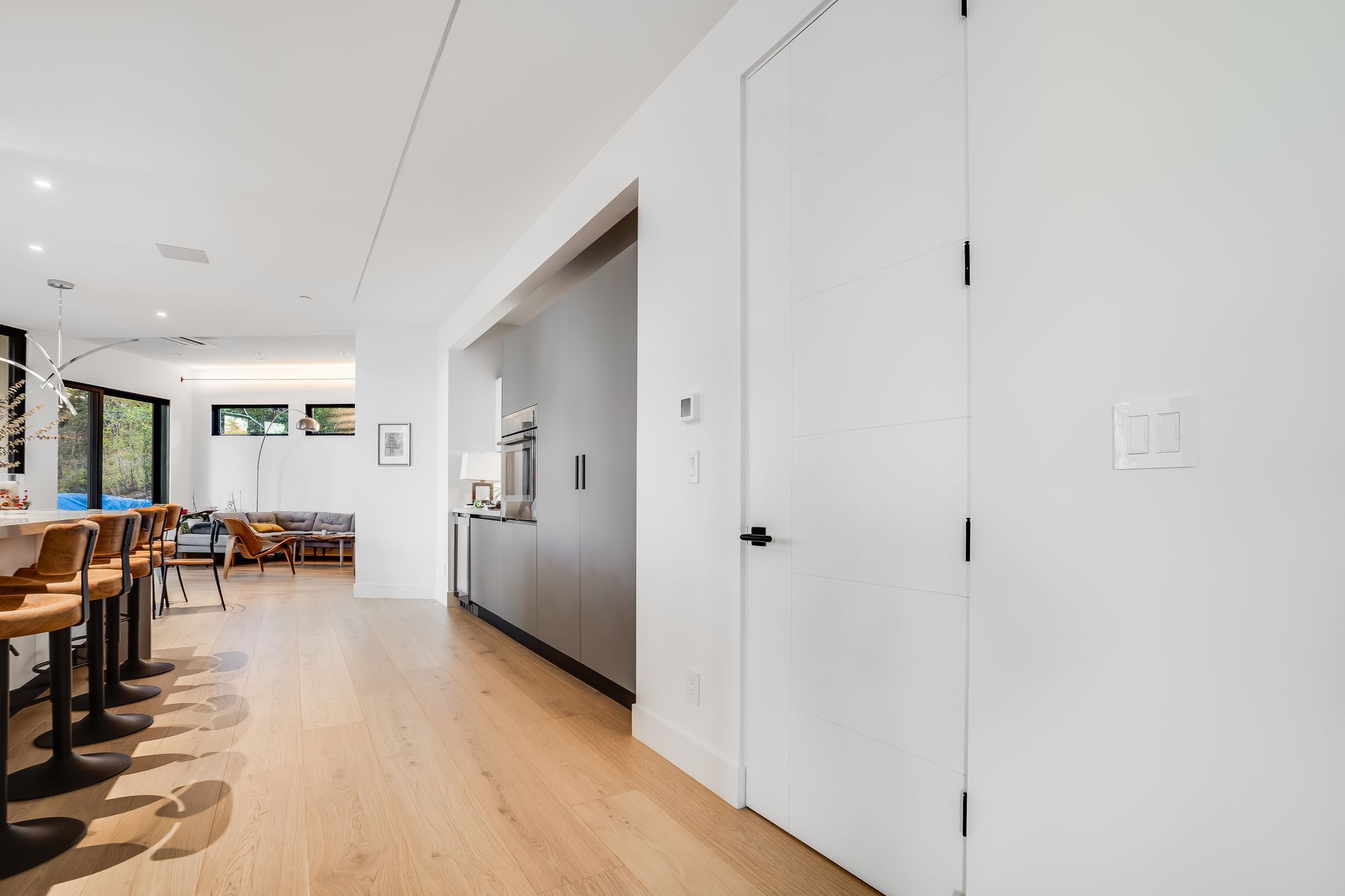 A hallway leading to a kitchen and living room in a house.