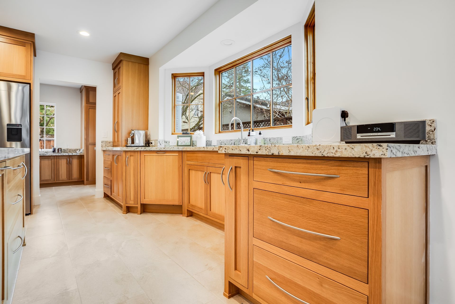 A kitchen with wooden cabinets , granite counter tops , and stainless steel appliances.