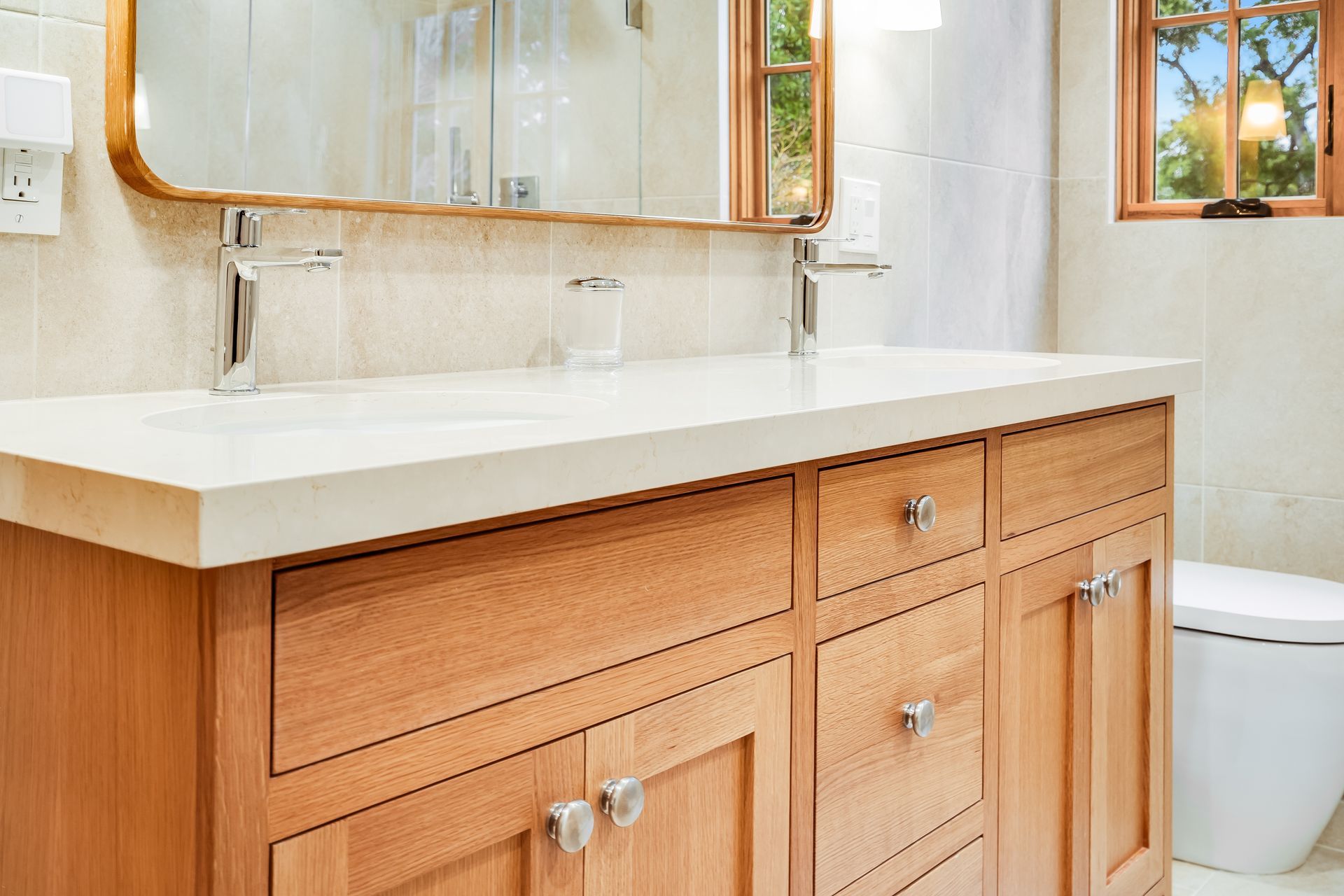 A bathroom with two sinks , a toilet , and a mirror.