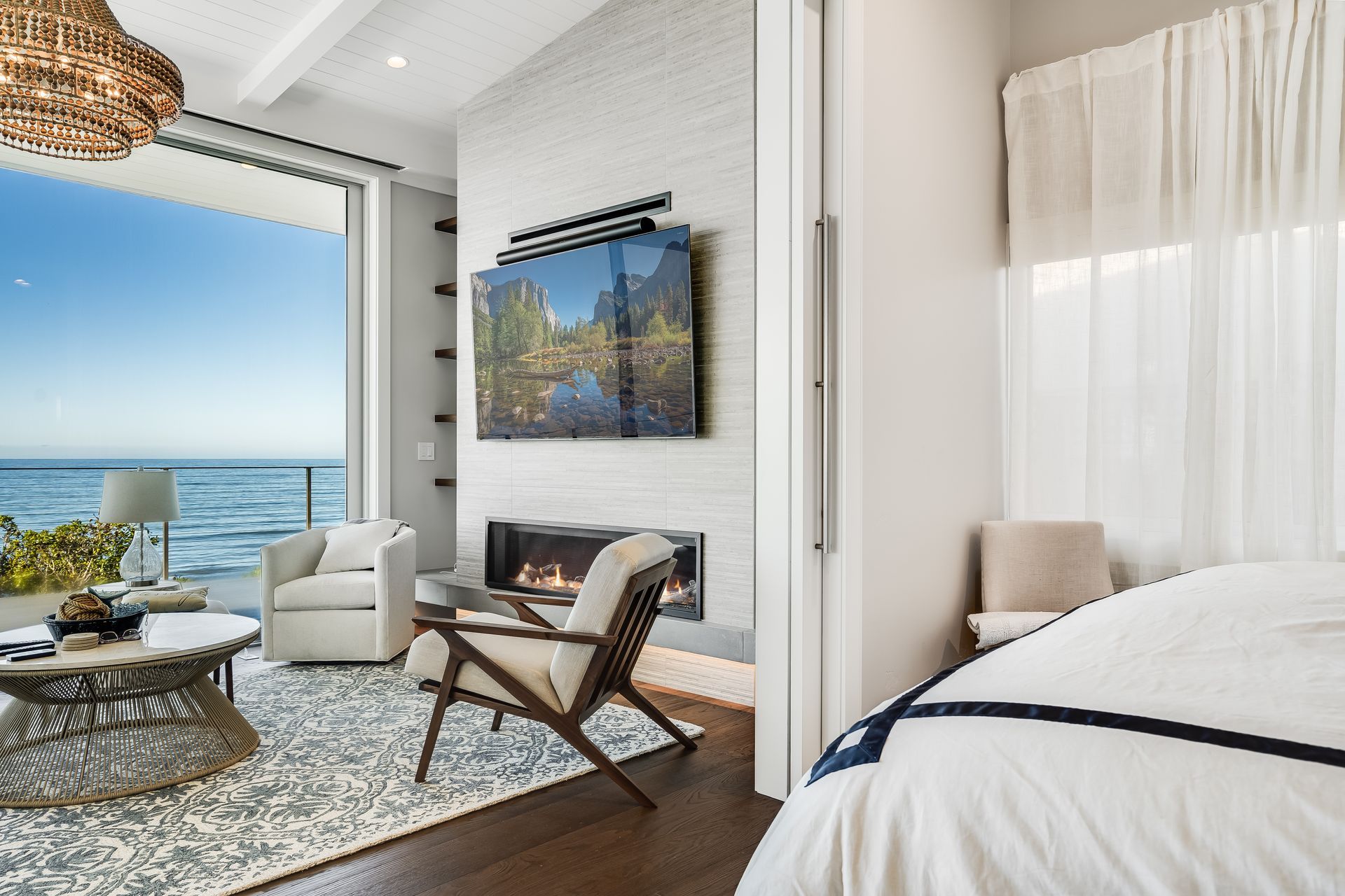 A bedroom with a fireplace and a television on the wall.