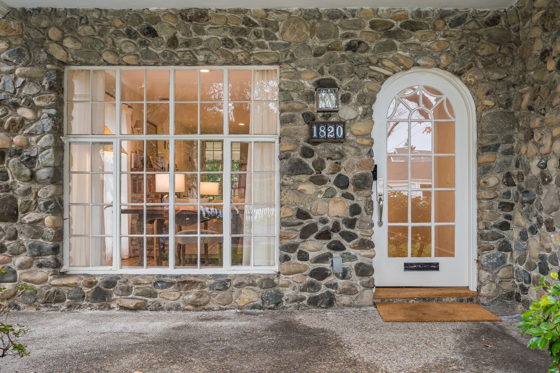 A stone house with a white door and a large window