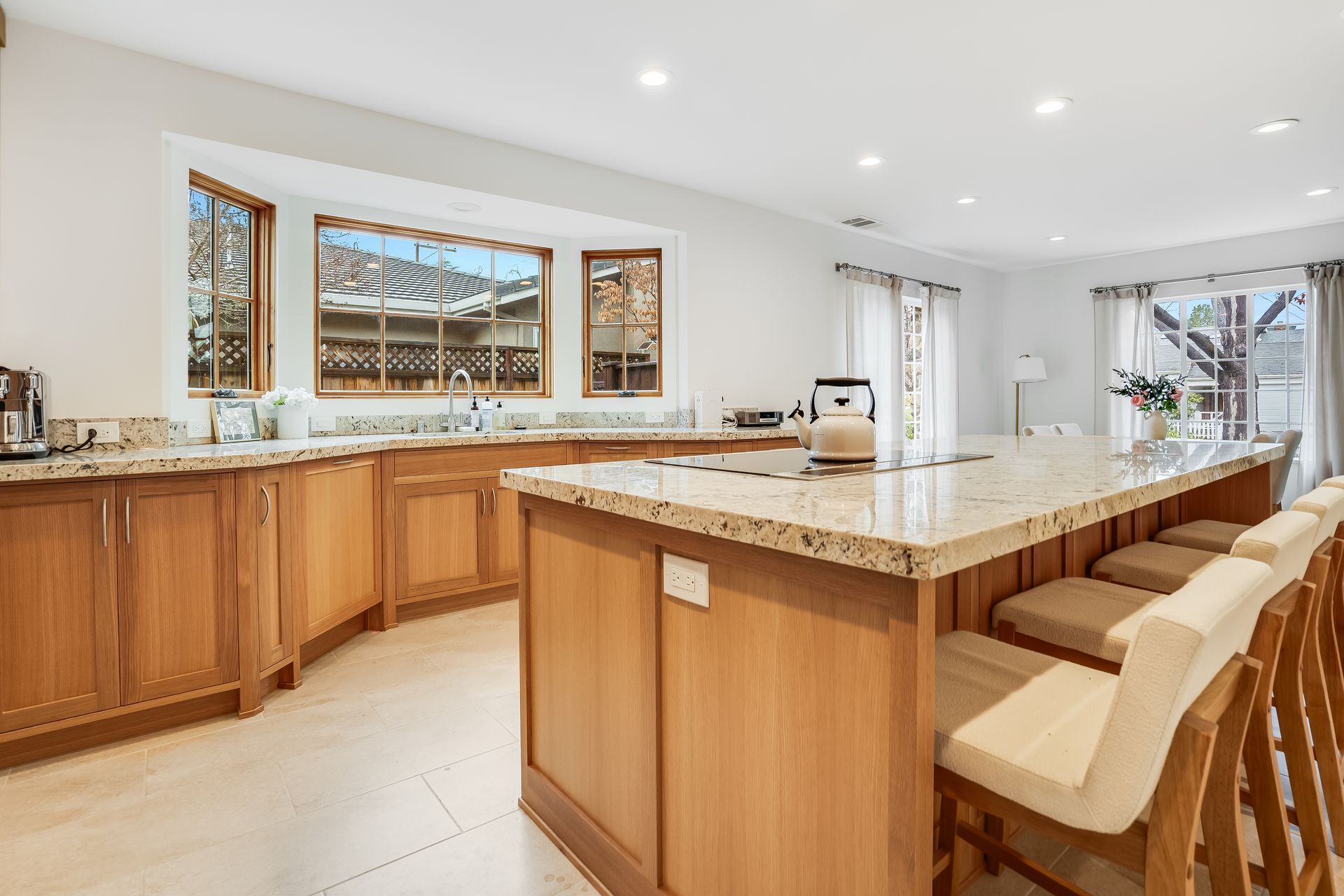 A kitchen with wooden cabinets , granite counter tops , and a large island.