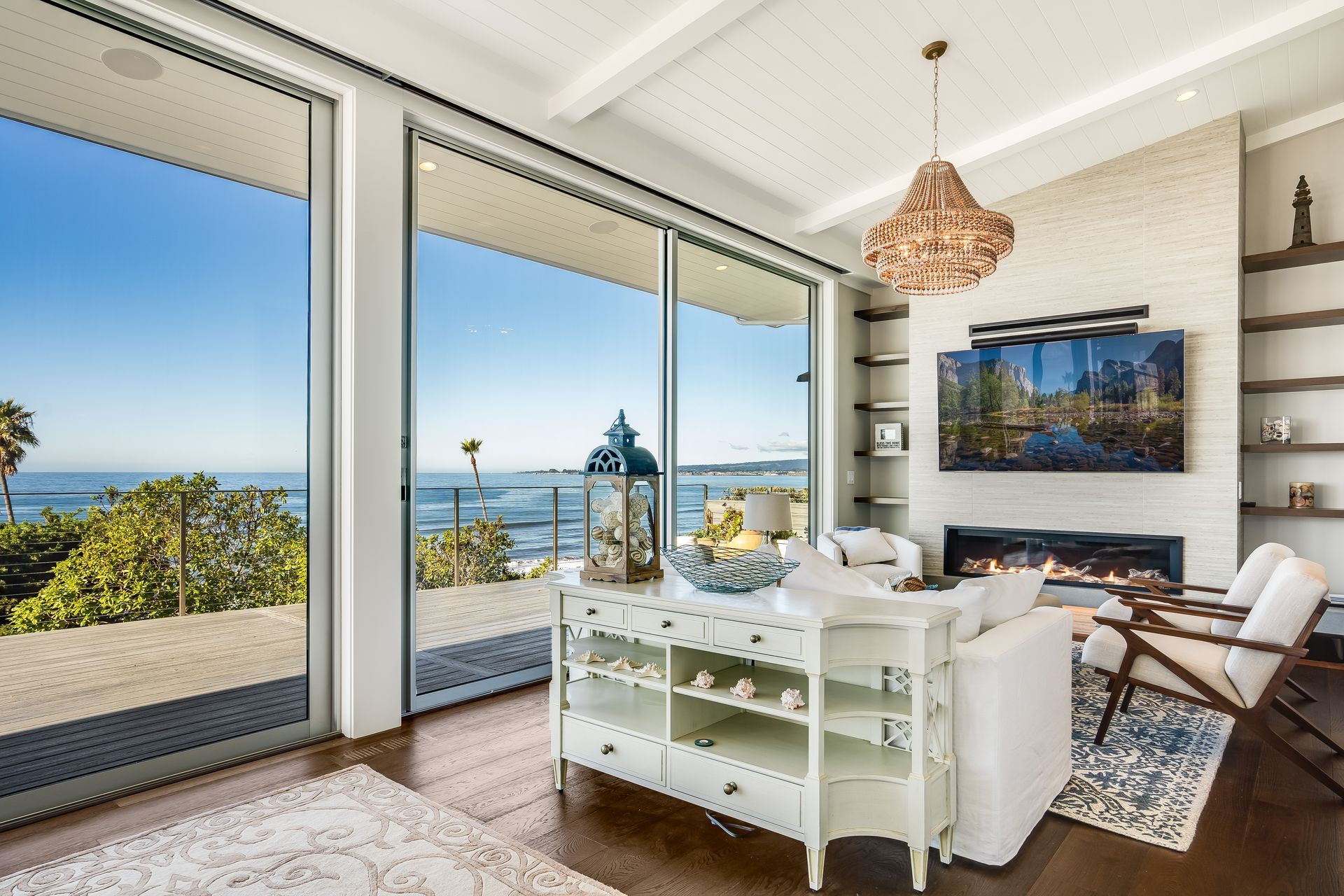 A living room with a fireplace and a view of the ocean.
