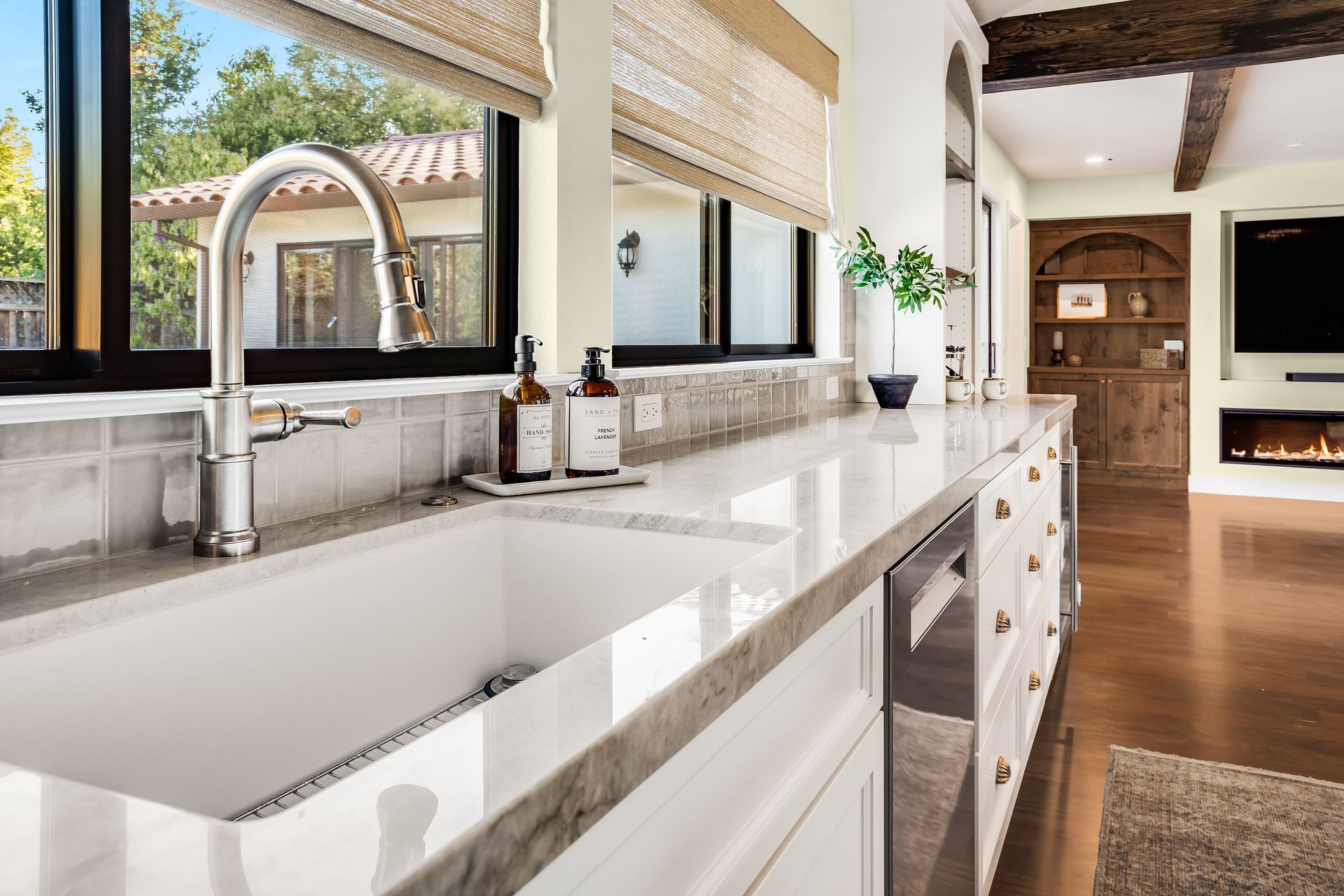 Kitchen with white cabinets, sink, and countertop. A window is in the background.
