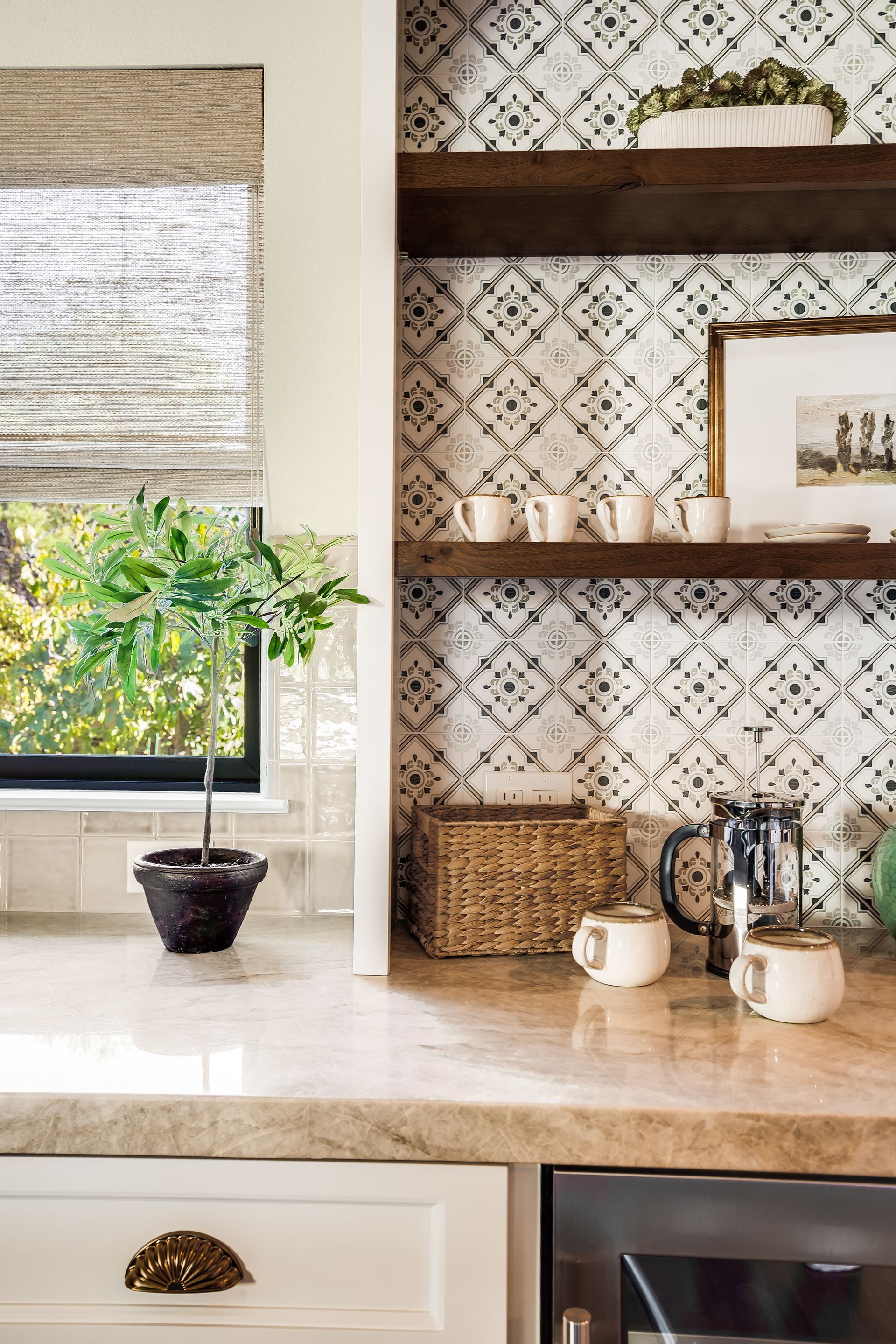 Kitchen with patterned tile backsplash, wooden shelves, and white cabinets.
