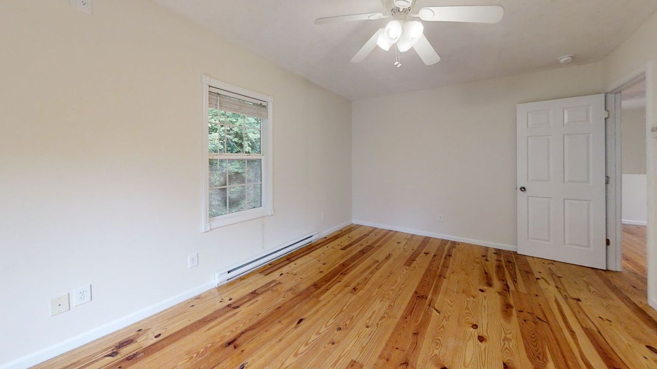 Junaluska Cabin -Living room with fan and hard wood floors
