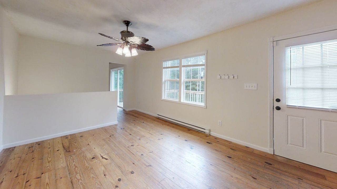 Junaluska Cabin -Living room with fan and hard wood floors and windows