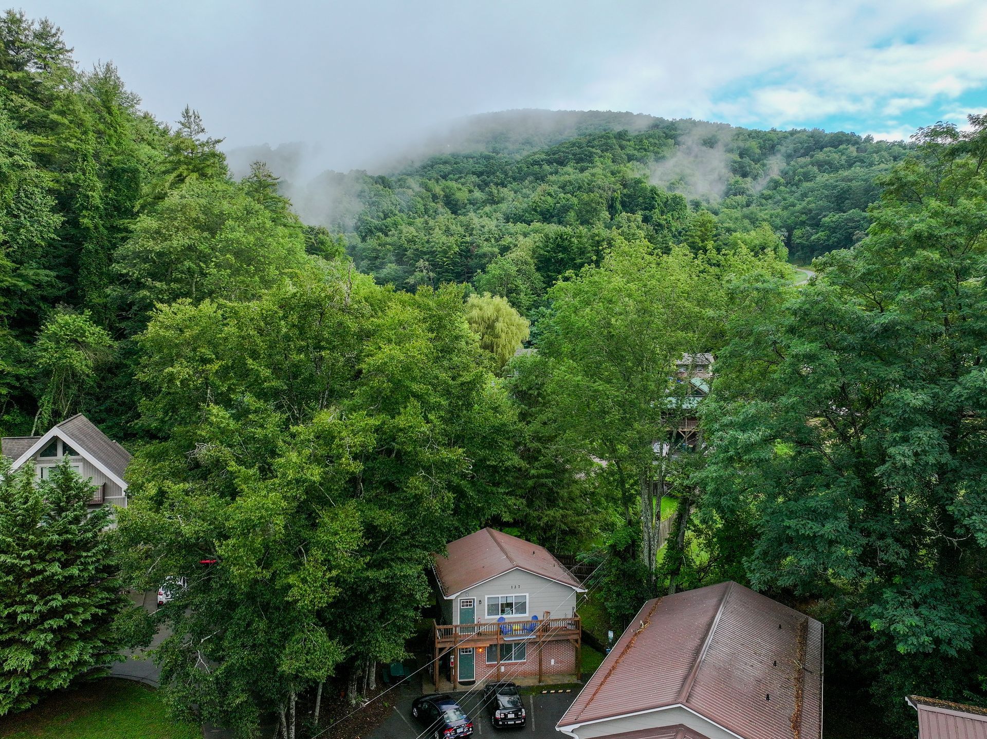an aerial view of a house in the middle of a forest