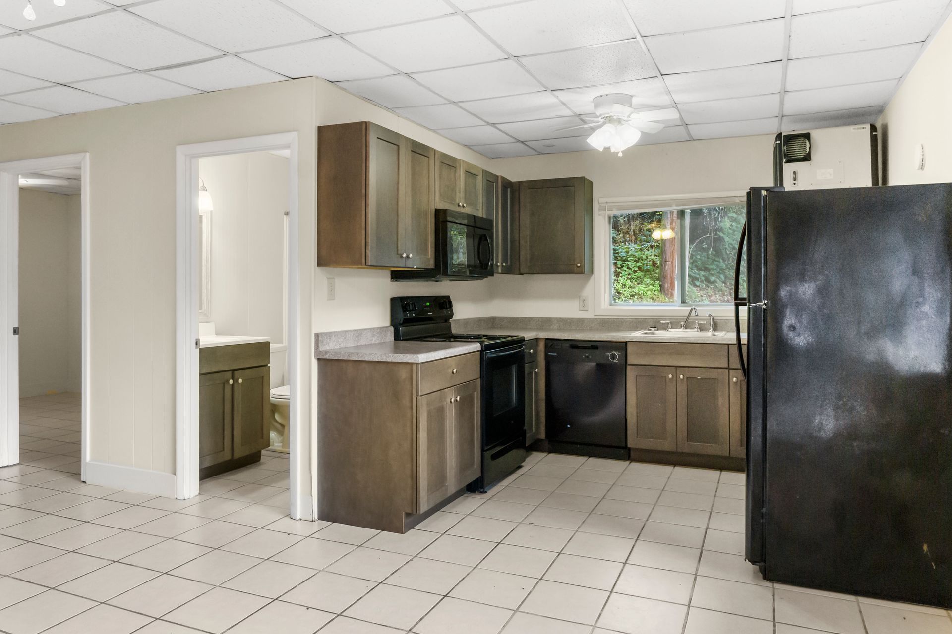 an empty room with a ceiling fan and a window