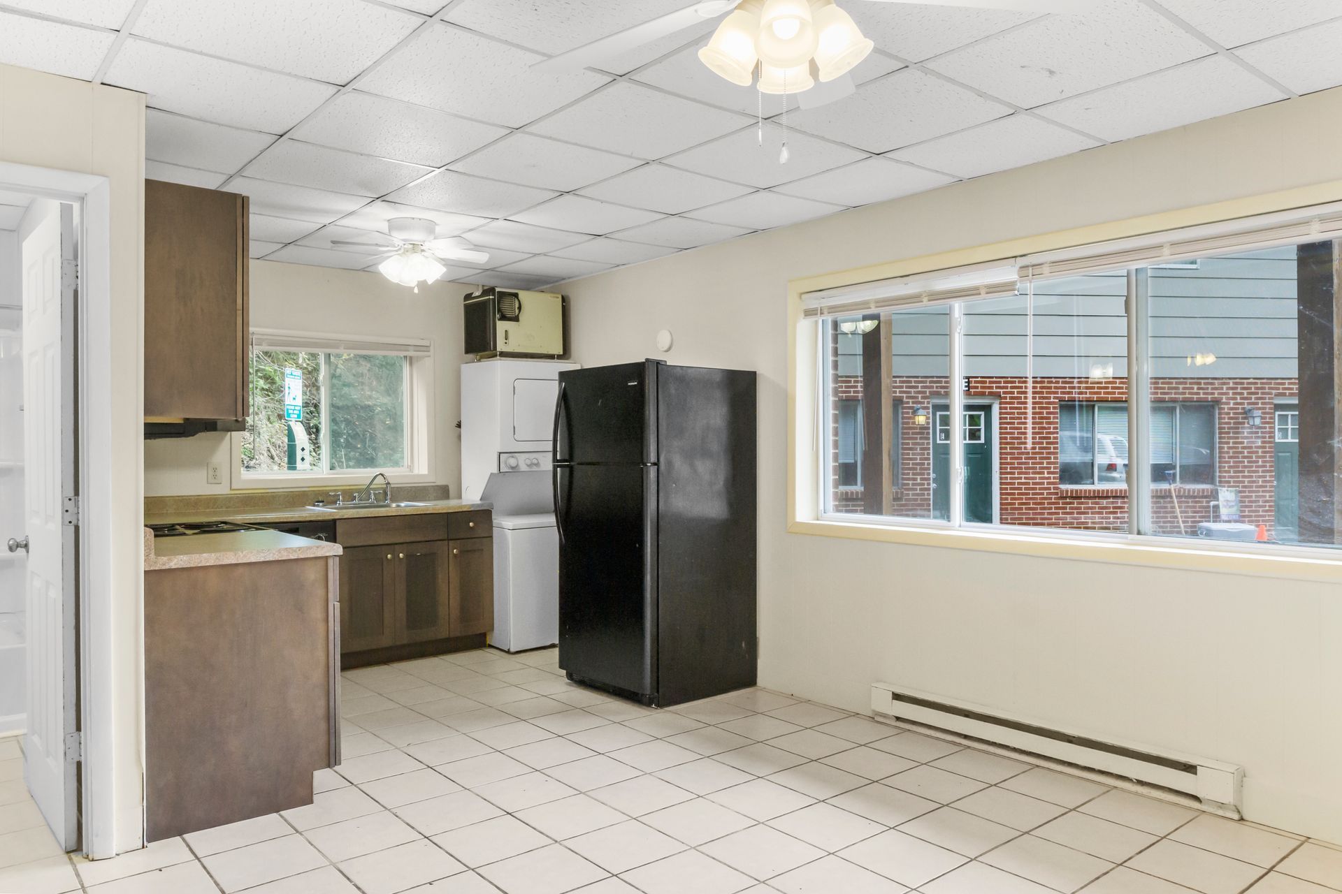 a kitchen with a black refrigerator and a window