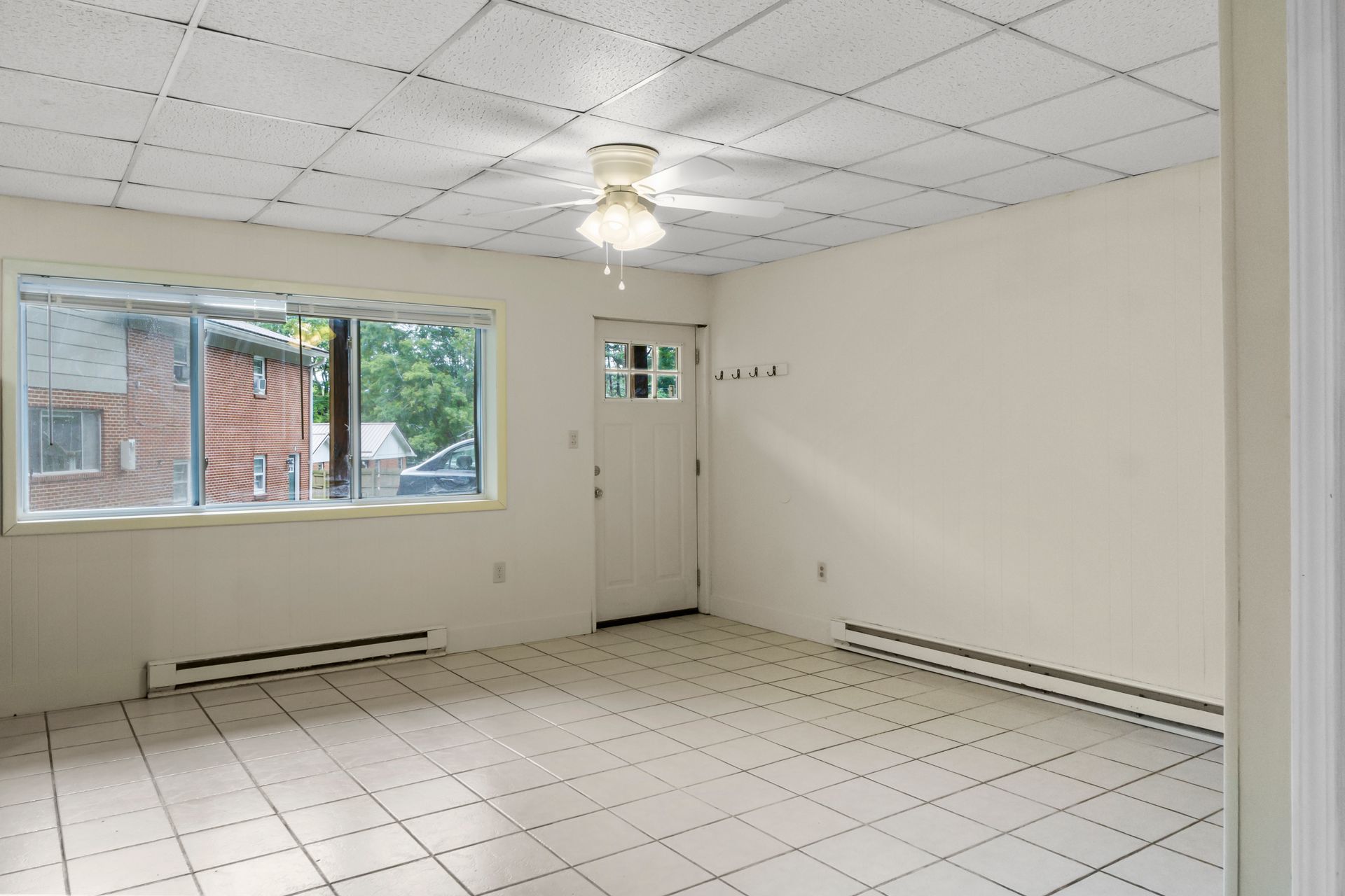 an empty room with a ceiling fan and a window