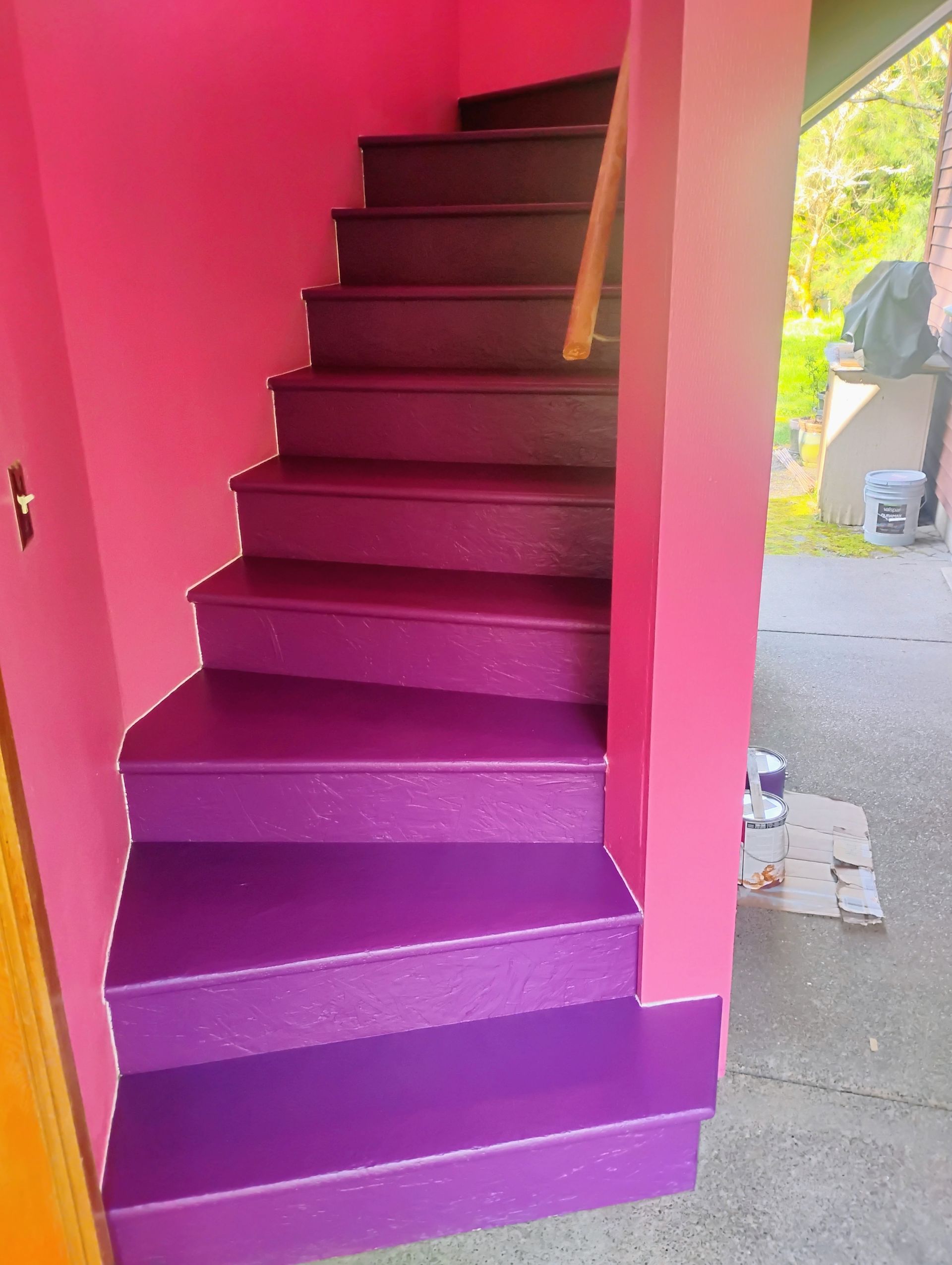 Purple painted stairs with pink walls, leading upwards.