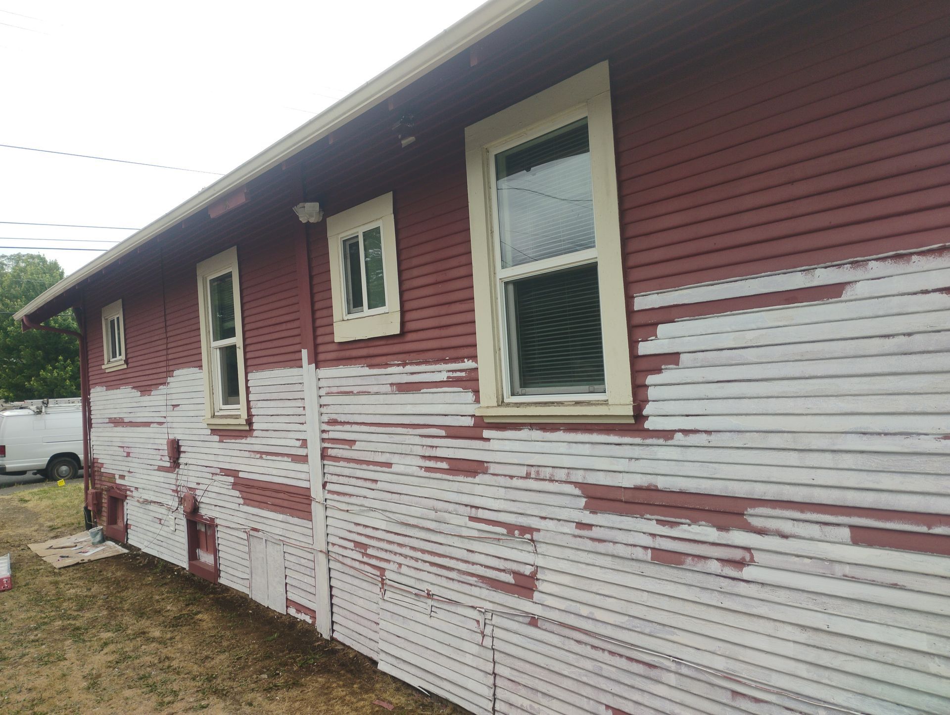 Bedroom interior: light-colored walls, gray paint swatch. Window on the right, open door on the left, unmade bed.