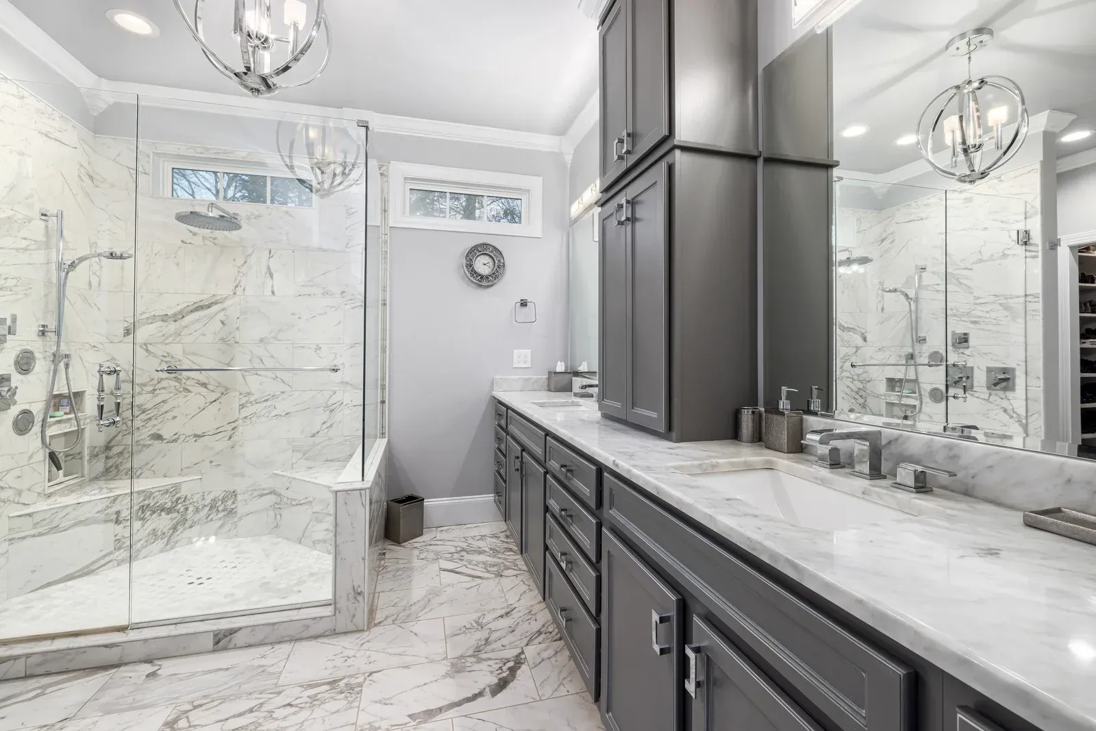 A bathroom with two sinks , a walk in shower , and a large mirror.