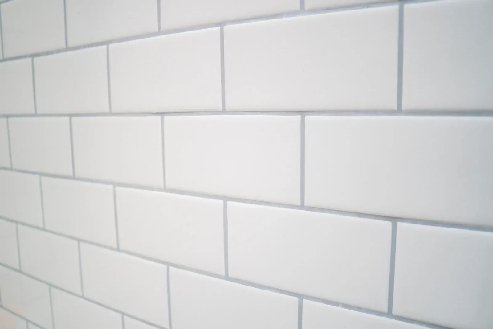 A close up of a white subway tile wall.