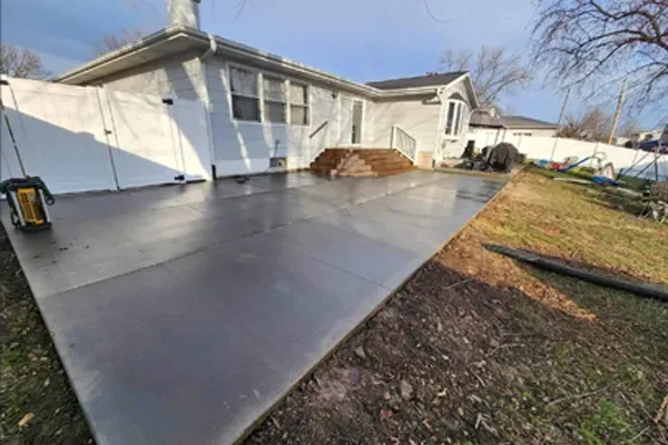 A concrete driveway is being built in front of a house.