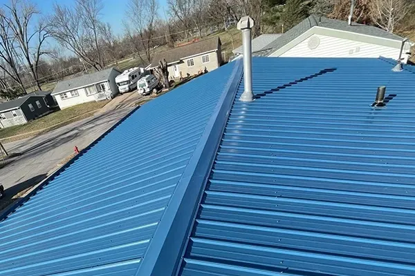 A blue metal roof with a chimney on top of it.