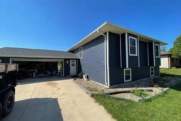 A house with a garage and a truck parked in front of it.