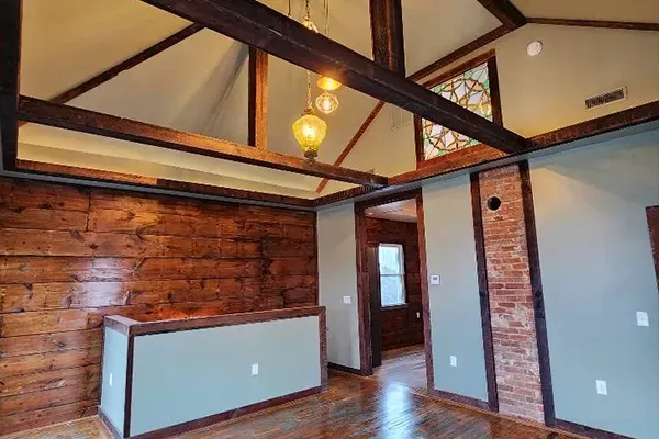 An empty room with a wooden wall and a stained glass window.