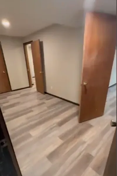 A hallway with hardwood floors and wooden doors in a house.