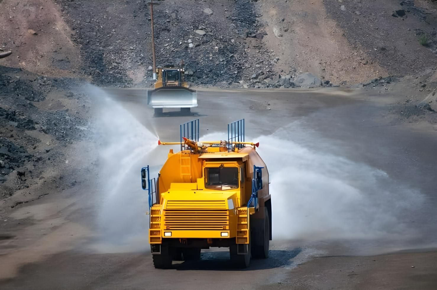 A Yellow Truck is Spraying Water on a Dirt Road — Husky Demolition In Heatherbrae, NSW