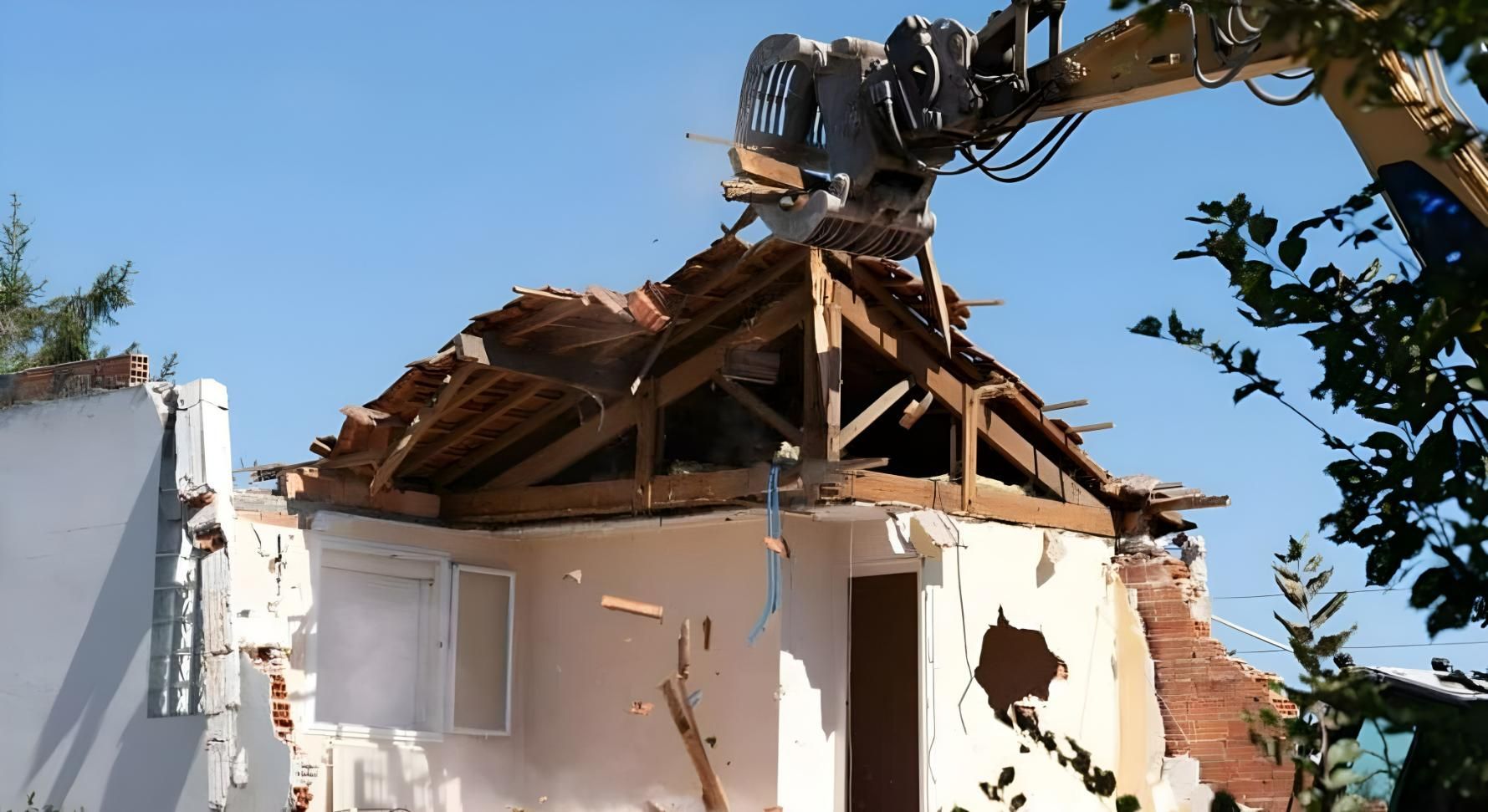 A House is Being Demolished by a Large Machine — Husky Demolition In Heatherbrae, NSW