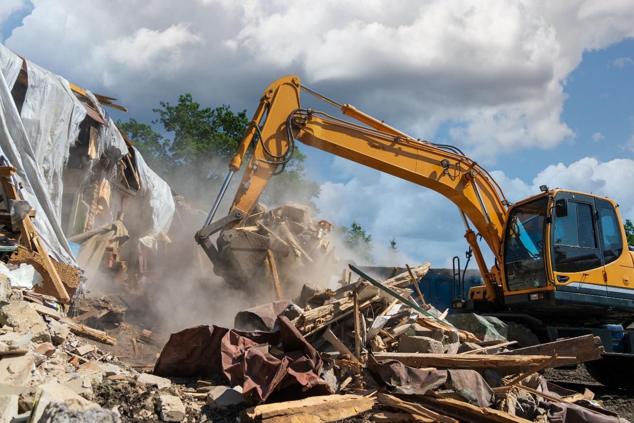 A Excavator is Demolishing a Building — Husky Demolition In Waratah, NSW