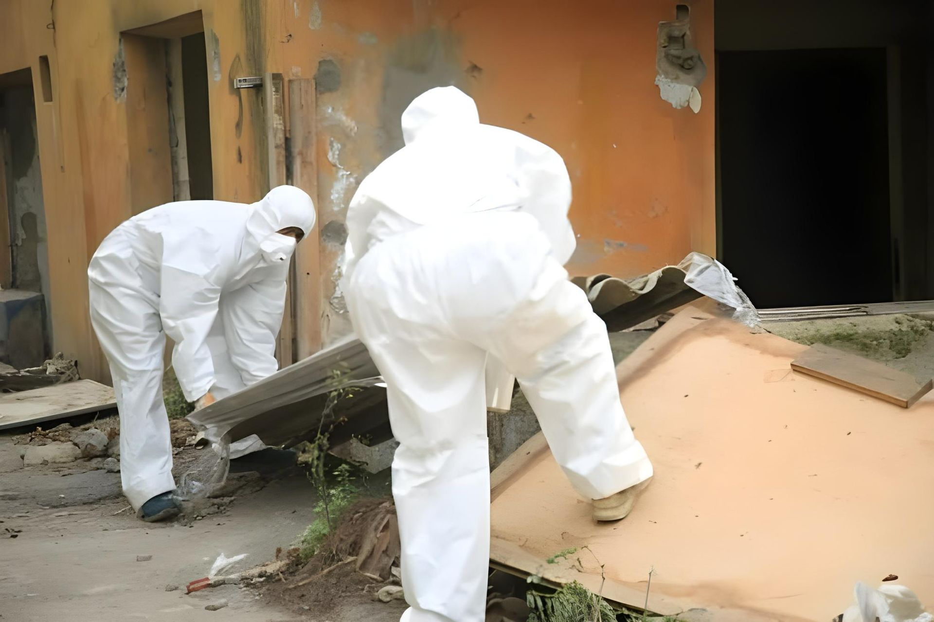 Two men in protective suits are working on a building — Husky Demolition In Heatherbrae, NSW