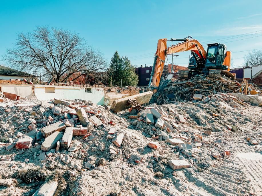 A Construction Site With a Pile of Rubble and a Bulldozer — Husky Demolition In Singleton, NSW