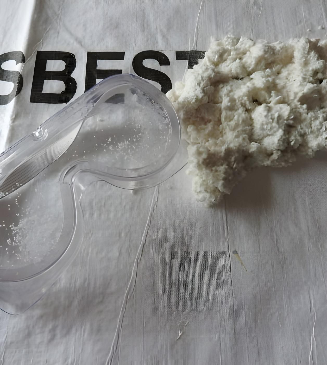 A Pair of Goggles and a Pile of White Powder on a Cloth That Says Asbestos — Husky Demolition In Heatherbrae, NSW