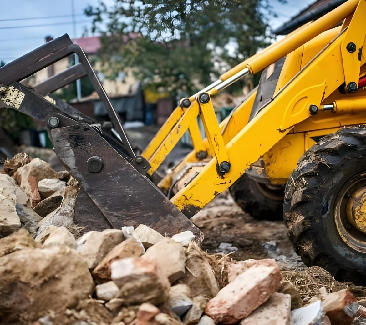 A Yellow Bulldozer is Moving Rocks on a Construction Site — Husky Demolition In Heatherbrae, NSW